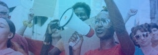 Woman holding a megaphone amid other protestors, photo credit iStock / Rawpixel