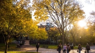 grants header for fwf 1920x1070.jpg Far away shot of people walking on campus at sunset, surrounded by trees