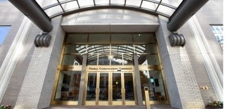 Front doors of Federal Communications Commission covered by a glass awning. Photo Credit: Marc Van Scyoc / Shutterstock