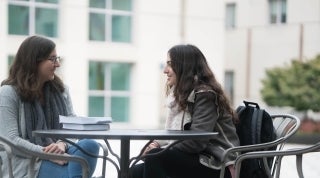 Student and TA 1920 x 1070.jpg Student sitting at a table with a graduate student TA outside the Annenberg building