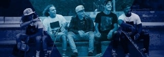 Group of five diverse teenage boys sitting in a skate park and holding skateboards, photo credit Parker Gibbons / Unsplash