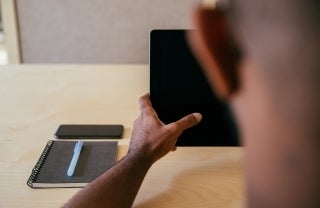 designer at a startup working on an iPad, photo credit Charles Deluvio / Unsplash