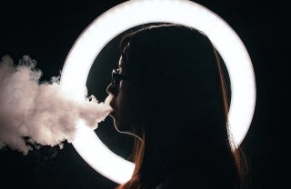 girl smoking with ring light behind her, photo credit John Caroro / Unsplash