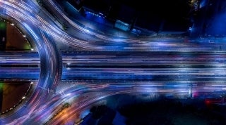CDCS connect with us Fullwidth 1920x1070 by Keattisak A on istock.jpg overhead view of a highway with lines of light on them that are the cars passing, Photo by Keattisak A on iStock