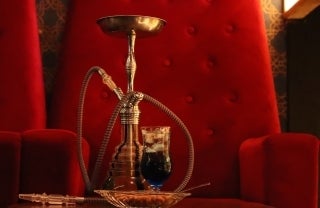 gold hookah sitting on red velvet chair; Photo by Awesome Sauce Creative on Unsplash