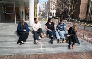 Students from Annenberg and SP2's inaugural Executive Program in Digital Media for Social Impact cohort sit outside talking and smiling: Stephanie Viggiano, Michael Ticzon, Megan Hurson, Jennifer Ingham, and Amanda Labrador.
