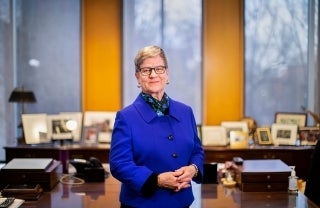 Kathleen Hall Jamieson standing in front of a desk smiling