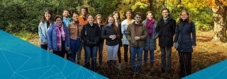 Group of people standing outside and posing for camera in fall weather