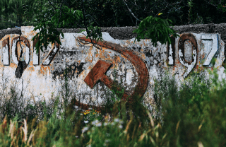 Destroyed wall of a building from Russia with the number (year) 1917, sickle and hammer.