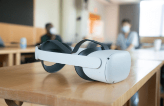 A VR headset placed on a table in a classroom