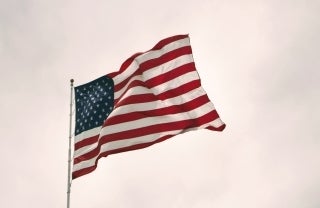 Closeup of an American flag flying in the wind on a cloudy day