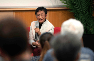 Maria Ressa speaks into a microphone