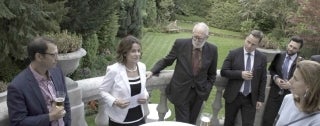 People standing around talking in a garden at a reception