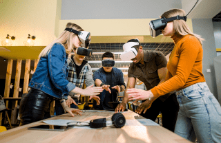A group of people wearing VR headsets stand around a conference table