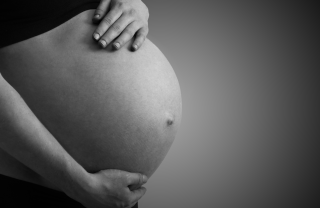 A close-up of a pregnant person's belly