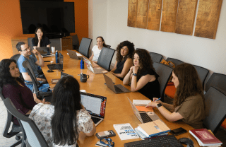 CARGC residents sit at a large conference table in the CARGC office