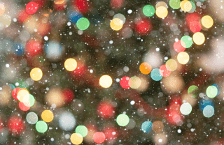 A blurry image of a Christmas tree with colorful lights and snowflakes