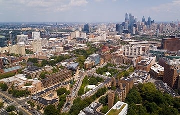 Aerial view over Penn's campus with the skyline of Philadelphia in the background