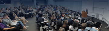 Annenberg Lecture 2016_Option2.png Group of people listening to a lecture