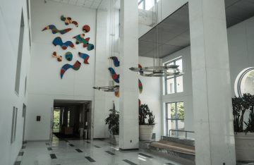 white room with colorful abstract art on top side of the wall, above the entrance