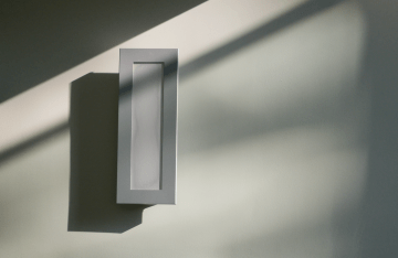 white rectangular box on a white wall with various shadows 