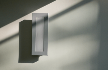 white rectangular box on a white wall with various shadows