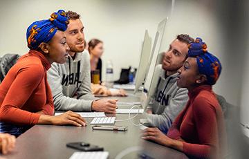 Two students looking at a computer screen together