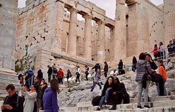 Students sitting on the steps of ruins in Greece