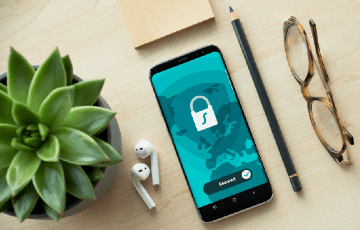 Photo of cellular device, AirPods, glasses and a pencil laying on a table. Photo credit: Dan Nelson / Unsplash