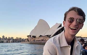 Student smiling in front of the Sydney Opera House