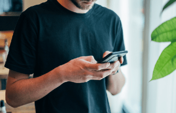 Photo of a man using a cellular device. Photo credit: Jonas Leupe / Unsplash