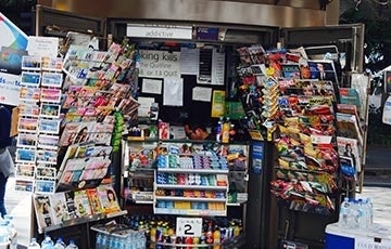Newsstand with many publications and candy and anti-tobacco signs in the window