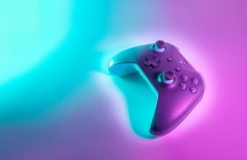 XBox game controller on a blue and pink background, photo credit Javier Martinez for Unsplash