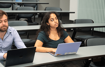 Two students on their laptops during a lecture