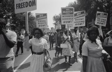 Women and men marching with signs in the 1960s during the Civil Rights Movement