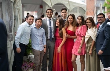 Group of people in formal clothing standing together posing for a photo outdoors