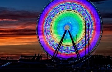 Ferris wheel at night in National Harbor, Maryland that is lit up with colorful lights