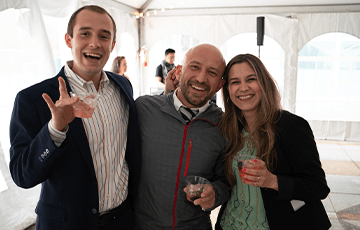 3 Annenberg staff members smiling at an outdoor event