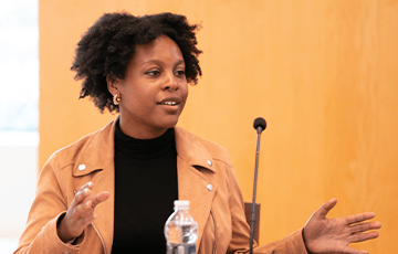 Woman talking in front of a microphone at an event
