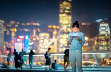 Woman looking at her phone outdoors in Hong Kong