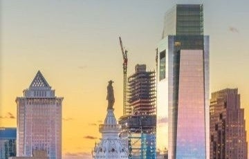 The top of city hall and comcast building at sunset