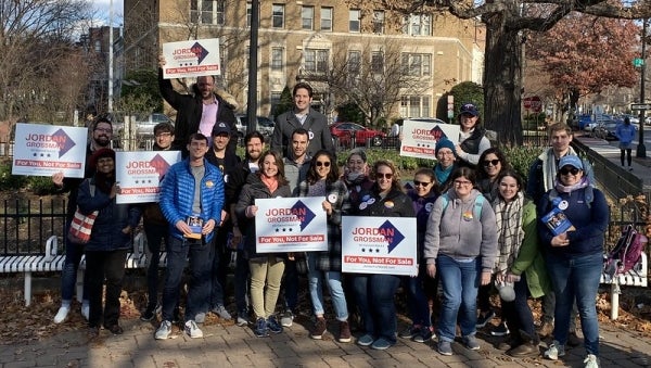 Group of people holding political signs for Jordan Grossman