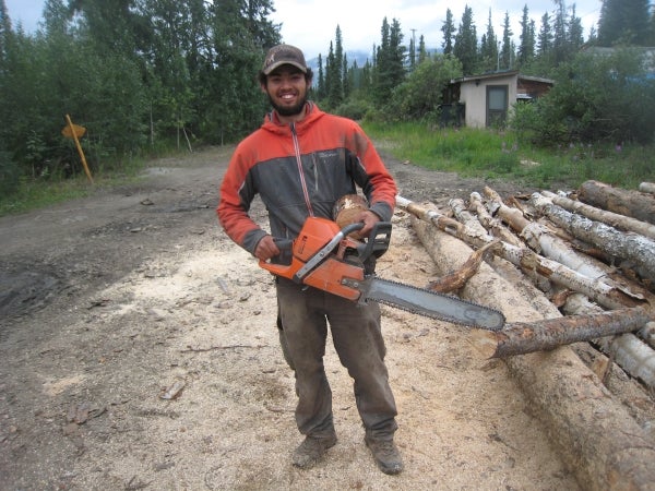 Man standing next to timber with a chainsaw