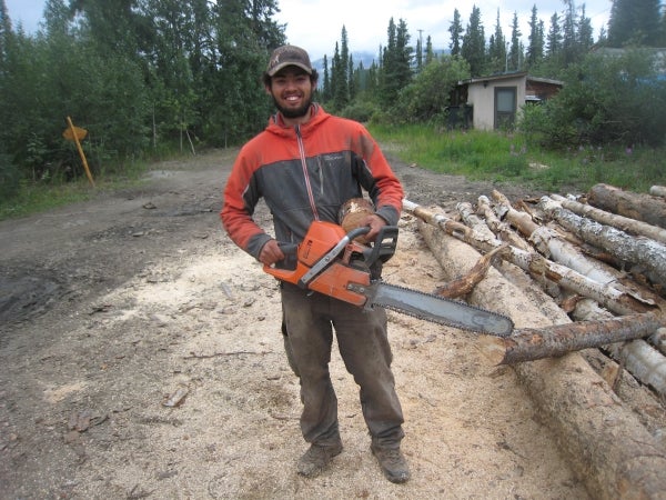 Man standing next to timber with a chainsaw