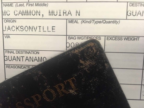 Corner of a passport laying over a document with the name "McCammon, Muira N", Origin: Jacksonville, Final Destination: Guanatamo, photo credit Muira McCammon