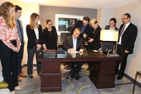 Paul Waldman seated at his desk, surrounded by Annenberg doctoral students