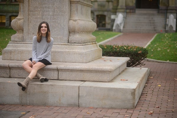 Elizabeth Heit sits on statue