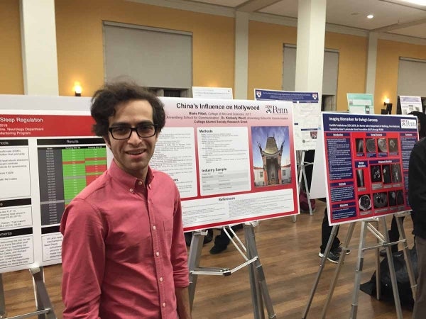 Blake Pittell poses in front of his thesis project