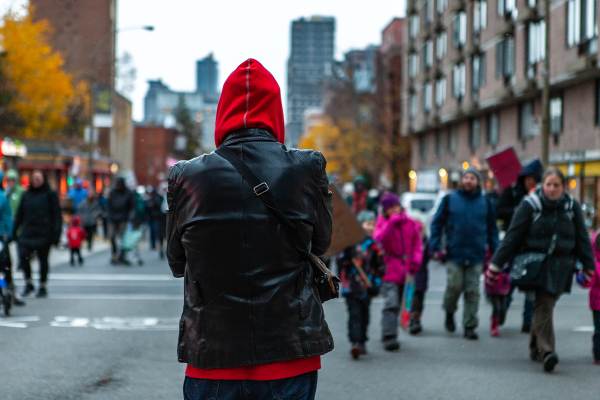 Person standing and watching others on a city street