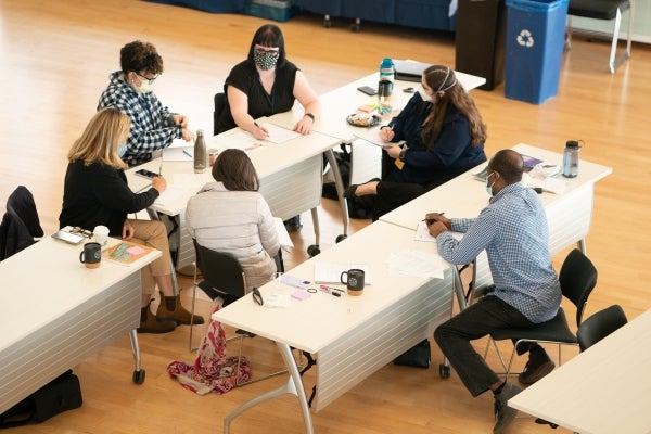 Masked students in the DMSI program chatting at long tables